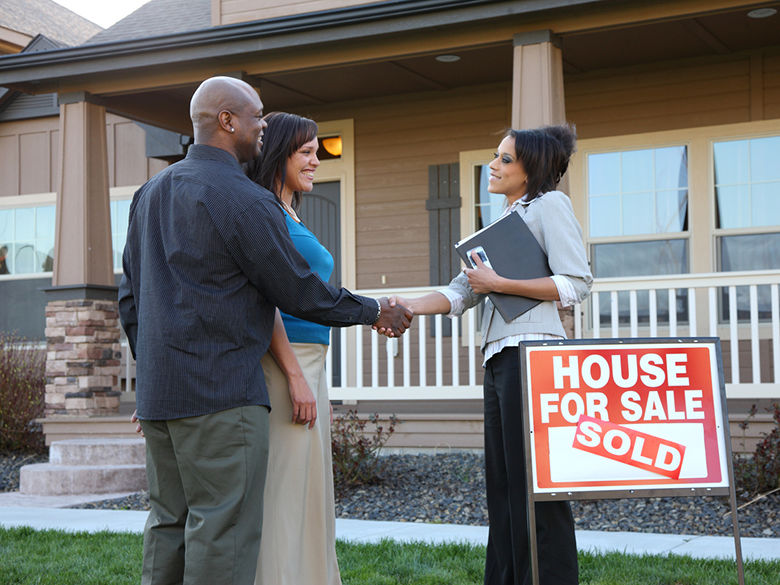 Couple shaking hands with a realtor.