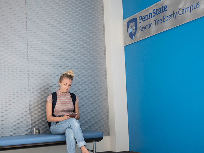 Student sitting in the hall way in the Eberly Building. 